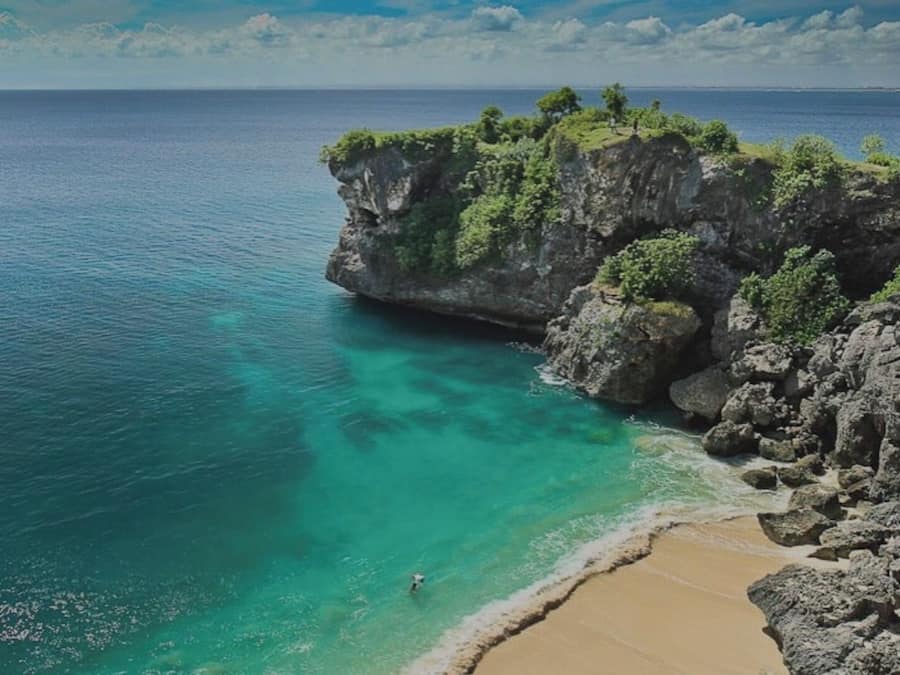 Pantai di sekitar, pasir putih, kursi berjemur, dan payung pantai