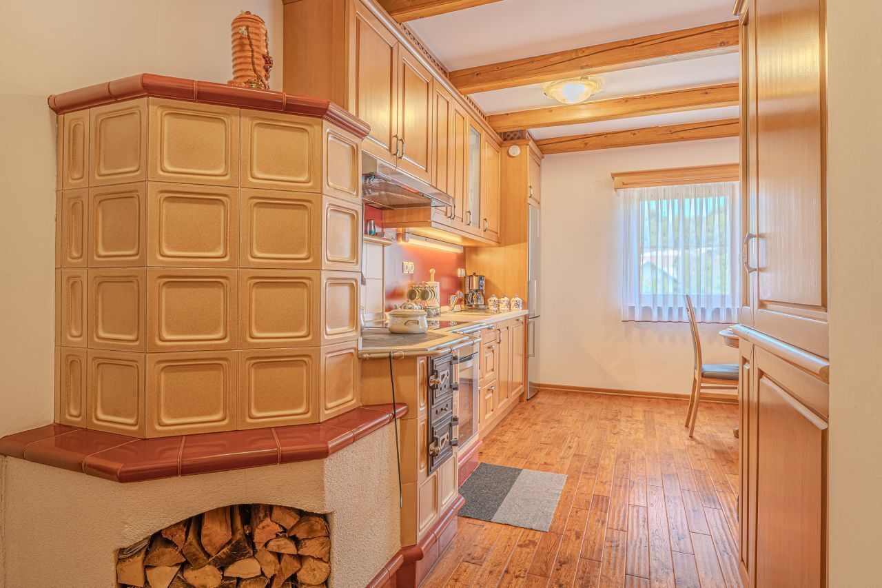 A kitchen with wooden cabinets, a built-in oven, and a fireplace.