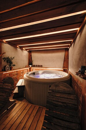 A hot tub in a wooden room with a brick wall and a wooden ceiling. - Vineyard cottage Škatlar 2 (Novo Mesto)