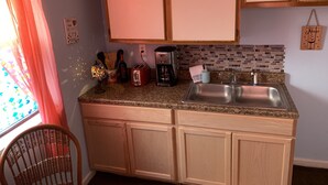 A kitchen with wooden cabinets, a granite countertop, a coffee maker, a toaster, and a sink. - Beach Side Studio #5 - Pet Friendly, WiFi, Off-Street Parking, Large Smart TV (Norfolk)