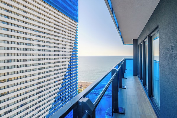Un edificio moderno con balcón con vista a la playa.
