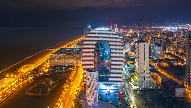 A modern hotel with a distinctive striped facade and a large central window. - Orbi City Hotel Official (Batumi)