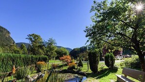 A serene garden with a pond, benches, and a variety of plants and trees. - Ferienwohnung Watzmann, für 4 Personen (Berchtesgaden)