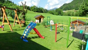 A playground with swings, slides, and climbing structures. - Ferienwohnung Watzmann, für 4 Personen (Berchtesgaden)