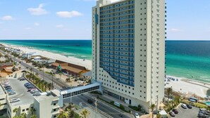 A high-rise hotel with a view of the beach and ocean.