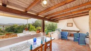An outdoor patio with a table, chairs, and a view of the landscape.