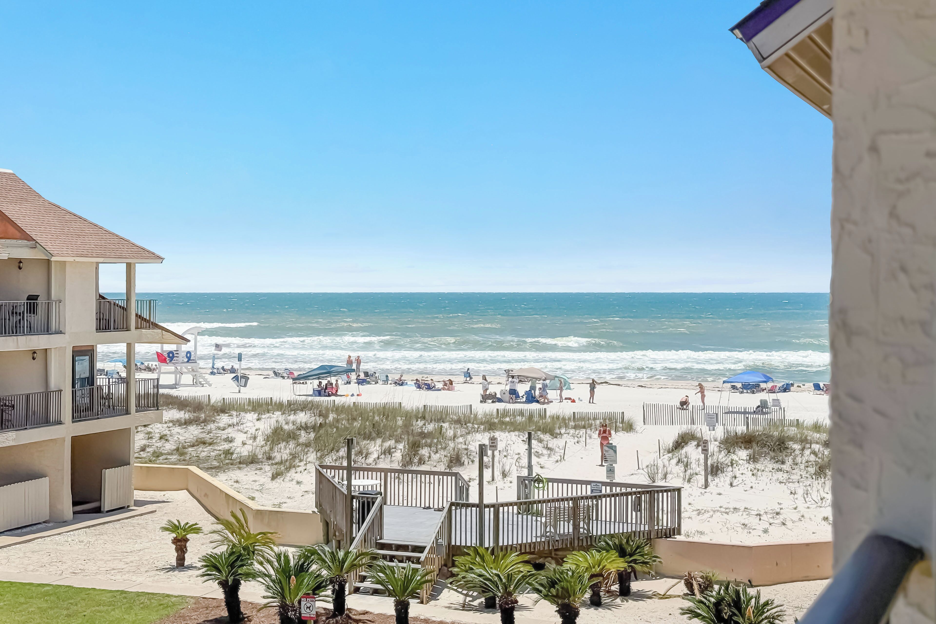 Un hôtel situé en bord de mer, doté d’un balcon, d’une plage de sable et offrant une vue sur l’océan.