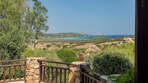 A stone balustrade overlooking a coastal landscape with a view of the sea and distant hills. - Casa Girgolu (Loiri Porto San Paolo)