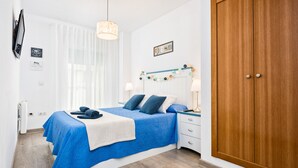 A bedroom with a bed, bedside tables, a wardrobe, and a window with curtains. - RELAX BY THE SEA, POOL, WIFI A / C. (Rincón de la Victoria)