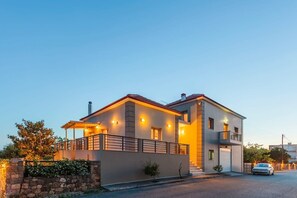 Une maison moderne à deux étages, dotée d’un balcon et d’un garage.
