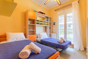 Une chambre d’hôtel avec deux lits, une bibliothèque et un balcon avec vue.