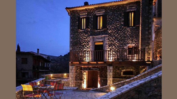 A stone building with a balcony and outdoor seating area. - Tsarbou Guesthouse (Gortynia)