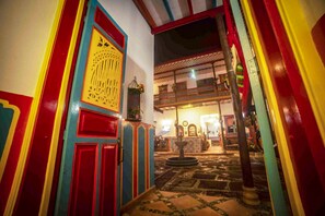 A colorful hallway with a patterned door and a fountain in the center. - Jardín by Bernalo Hotels (Jardin)