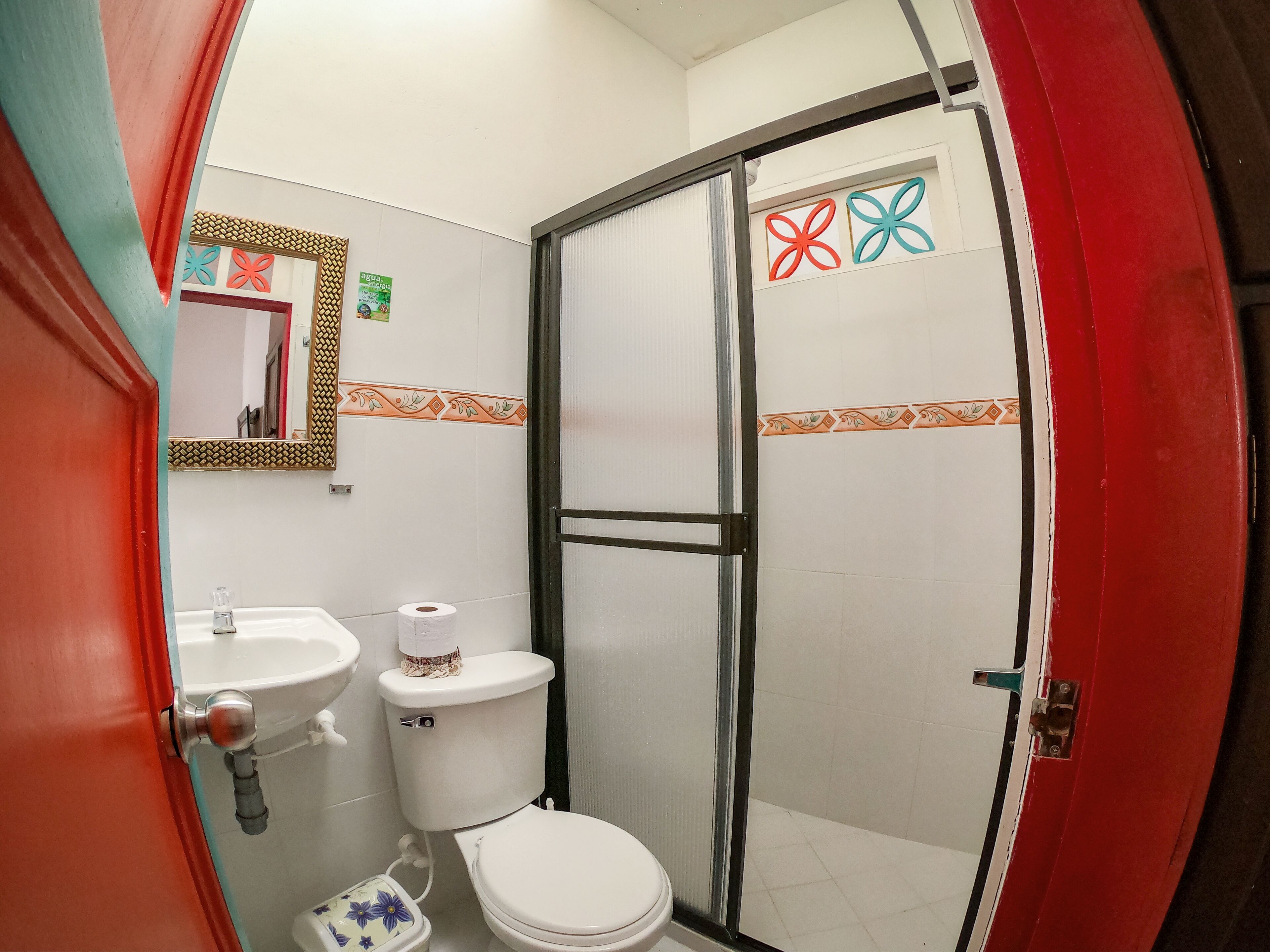 A bathroom with a toilet, sink, and shower area.