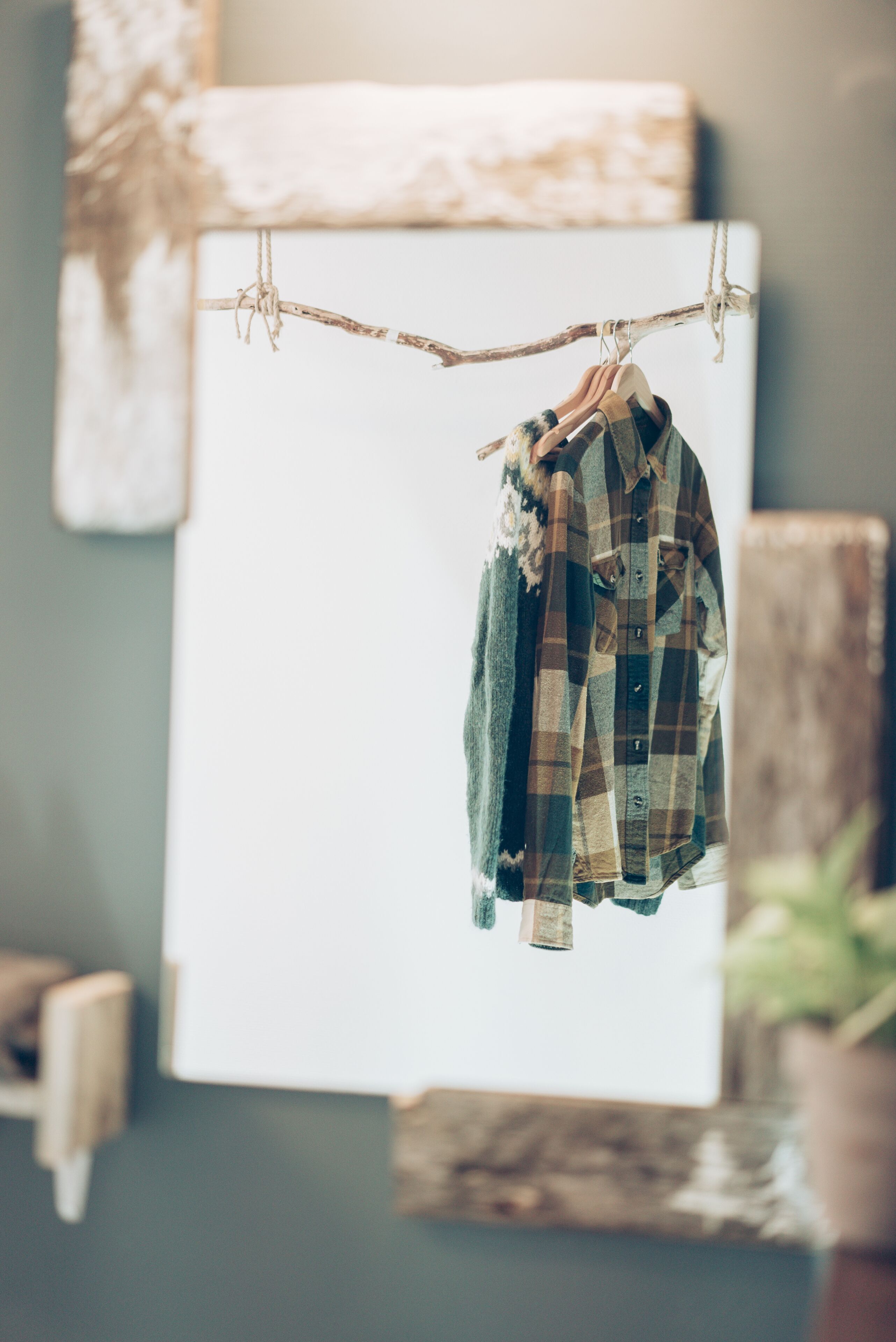 A plaid shirt hanging on a line in a room with a rustic decor, including a wooden beam and a whiteboard.