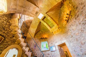 A stone interior with a staircase, arched ceilings, and framed artwork. - Rustic Finca in Mallorca Can Colis with pool (Sa Pobla)