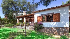 A two-story house with a stone facade, a wooden porch, and a small garden. - Wonderful private villa for 8 guests with WIFI, private pool, TV and patio (Calonge)