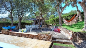 An outdoor patio with stone flooring, a pool, and a hammock. - Wonderful private villa for 8 guests with WIFI, private pool, TV and patio (Calonge)