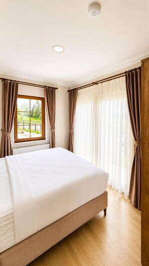 A bedroom with a large bed, a window with curtains, and a ceiling light. -  Raha Villa Bungalow (Çaykara)