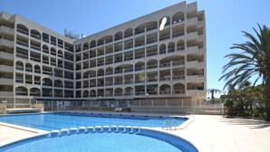 Un grand hôtel à plusieurs étages doté d’une piscine centrale.