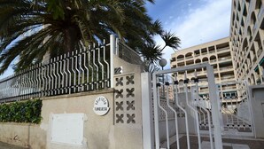 Une entrée fermée par un portail, sur laquelle on peut lire l’inscription « Edificio Turquesa », et, au fond, un immeuble doté de nombreux balcons.