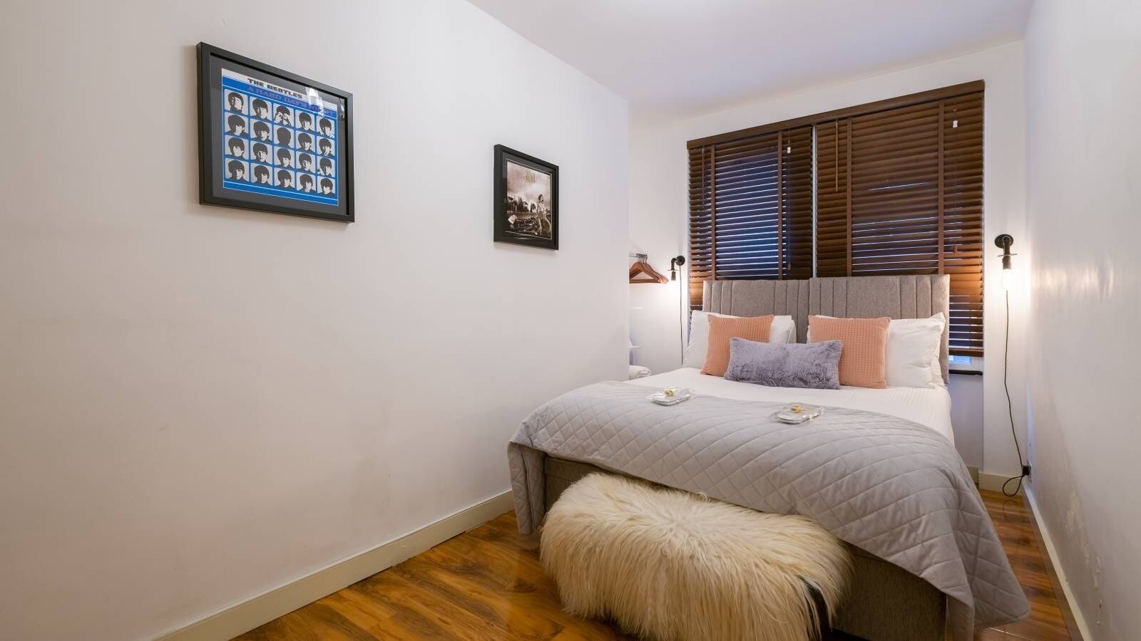Una camera da letto con un letto, un tappeto morbido, un quadro incorniciato e una finestra con persiane.