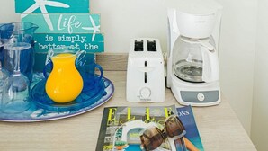 A breakfast setup with a coffee maker, toaster, and a magazine on a table. - Ocean Front Property - Villa 2 Aruba (Savaneta)