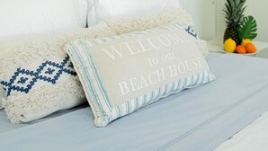A bed with a white headboard, two pillows, and a welcome sign. - Ocean Front Property - Villa 2 Aruba (Savaneta)