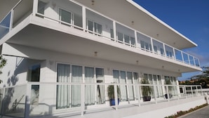 A modern two-story building with large windows and a balcony. - Beachfront Bella Horizonte 1 (Savaneta)