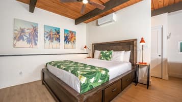 A bedroom with a wooden bed, a ceiling fan, and wall-mounted air conditioning.