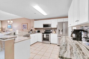 Enjoy cooking in this well-equipped kitchen with a central island, stove, microwave, refrigerator, and dishwasher.