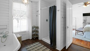 A bathroom with a bathtub, shower, and a window with blinds. - Country Farmhouse close to Texas A&M, wedding venues, & wineries! (Navasota)