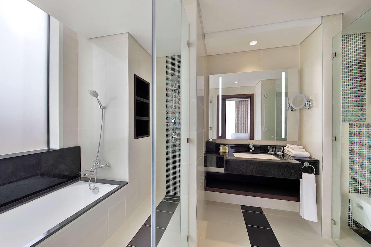 A modern bathroom with a glass-enclosed shower, a large mirror, and a dual sink vanity.