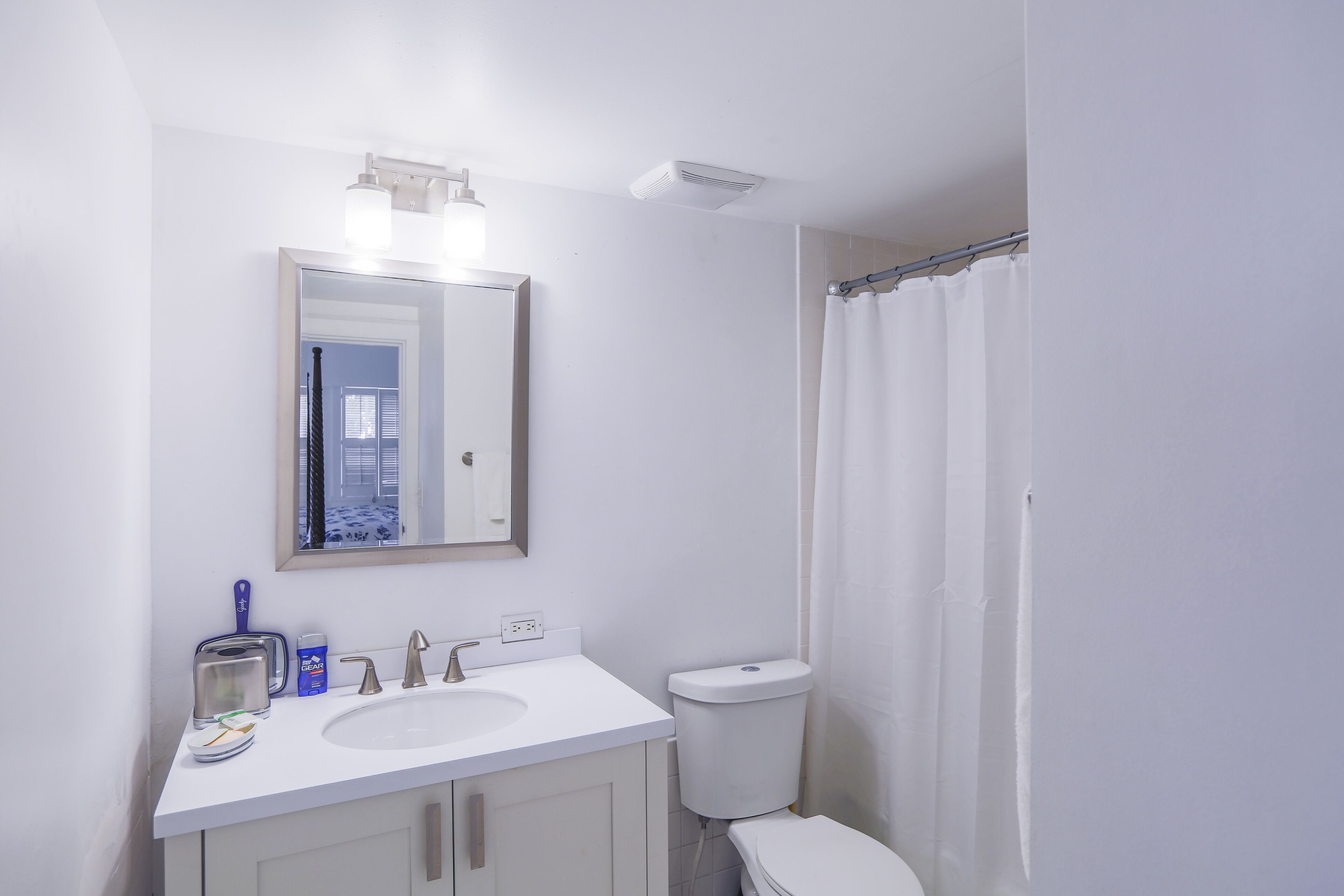 Ein Badezimmer mit Waschbecken, Spiegel und Toilette.