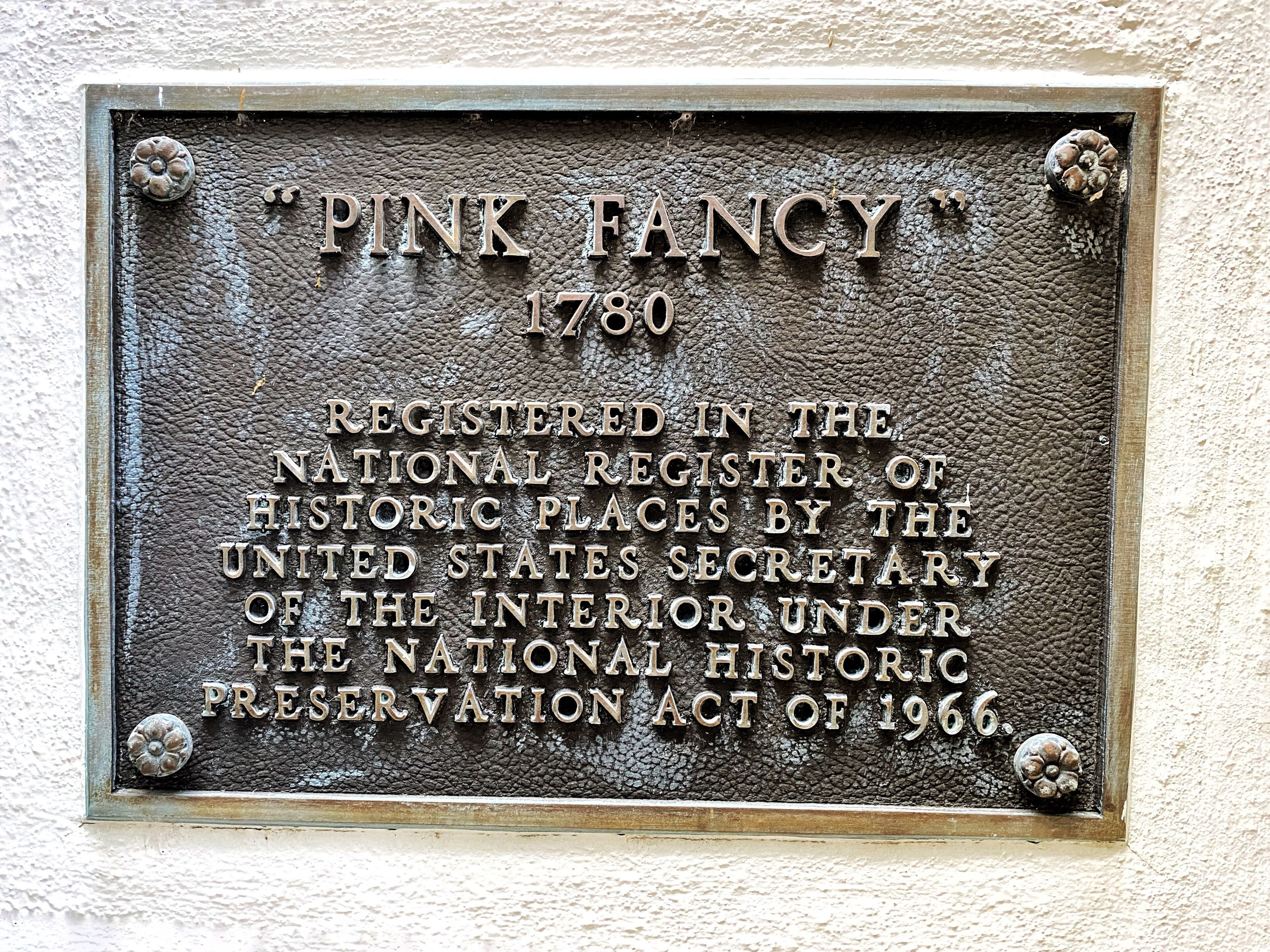 A plaque with the inscription "PINK FANCY 1780" and details about its registration with the National Register of Historic Places.