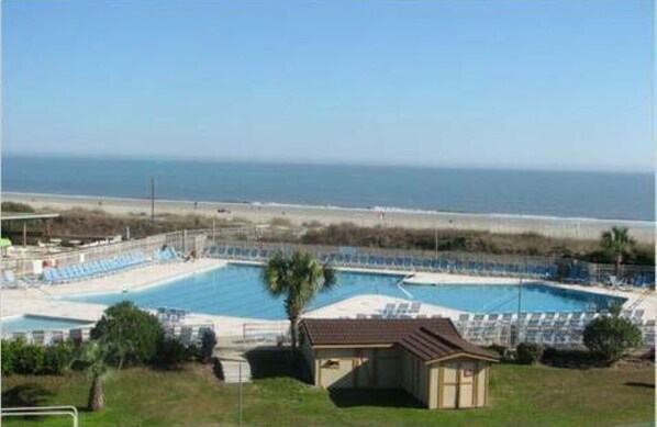 Relax by the pool with ocean views, surrounded by lounge chairs and umbrellas.