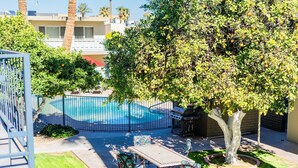 Un pati d'entrada amb una piscina, una barbacoa i una zona de menjador amb caires i taula.