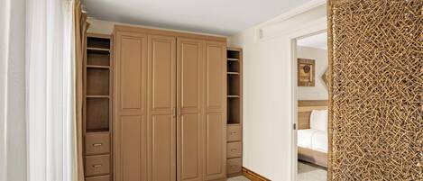 A bedroom with a large wardrobe, a bed with a wooden headboard, and a textured wall panel.