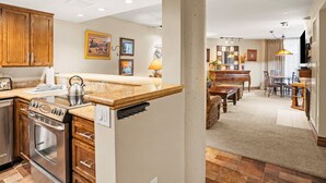A modern kitchen with wooden cabinets, a built-in oven, and a granite countertop.