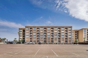 Un hôtel à plusieurs étages avec un parking situé à l’avant.