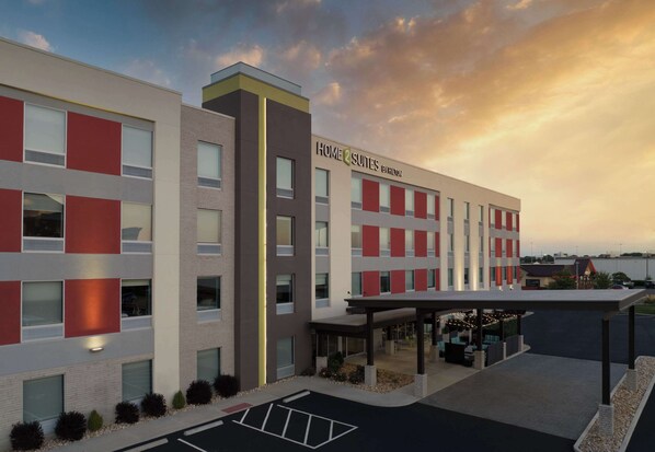 A modern hotel with a covered outdoor area, multiple floors, and a prominent signage. - Home2 Suites Troy (Troy)