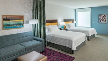 Una habitación de hotel con dos camas, un sofá, una mesita y un ventanal con cortinas.