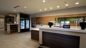 A hotel reception area with a counter, a minibar, and a refrigerator.