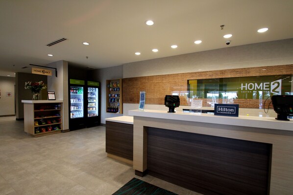 Zona de recepción de un hotel con mostrador, un minibar y un refrigerador.