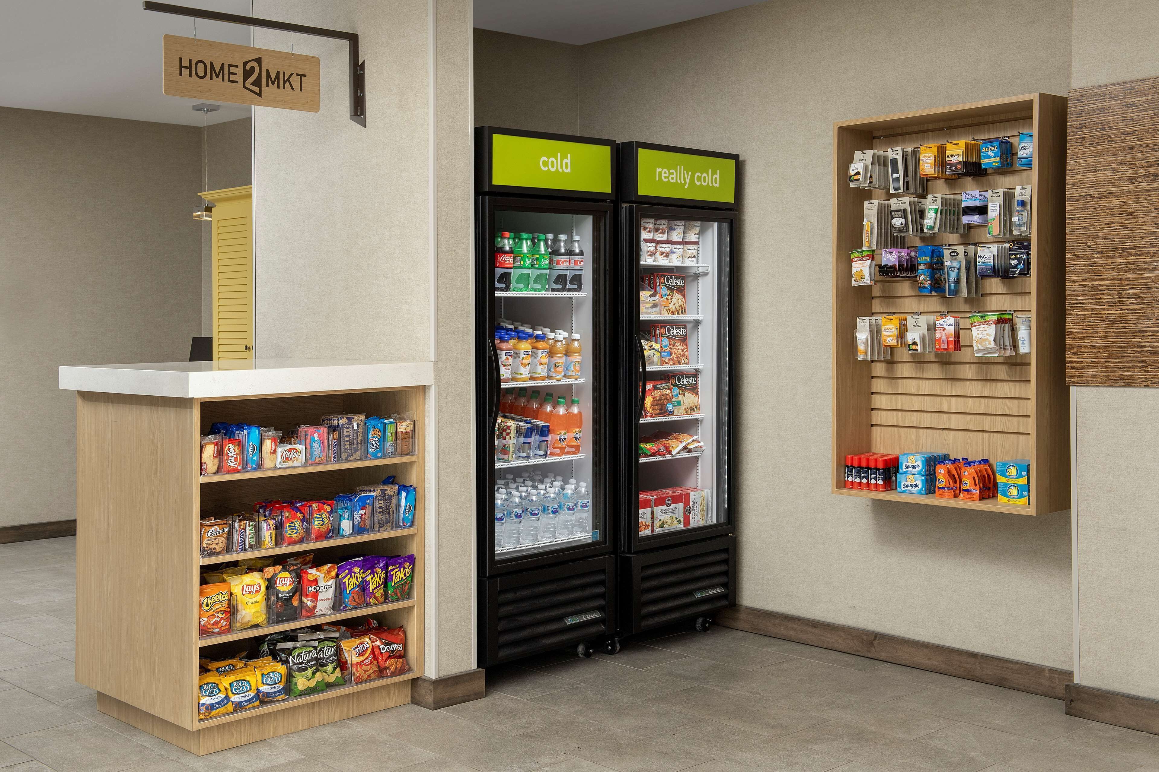 A snack and beverage kiosk with shelves stocked with chips, snacks, and bottled drinks.