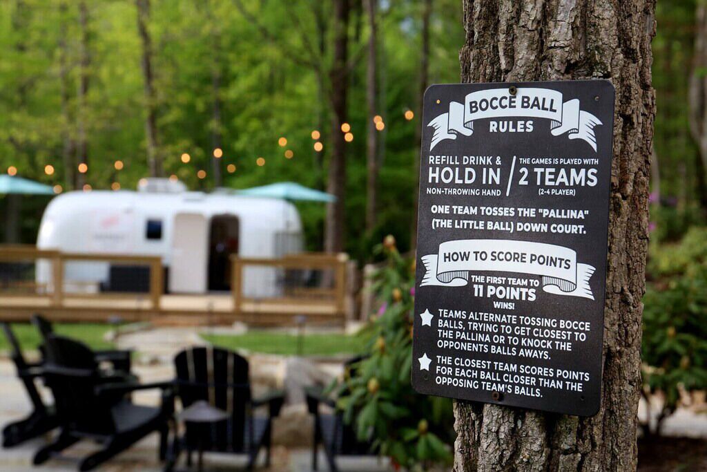 A sign with rules for a bocce ball game, including team size, scoring method, and game duration.