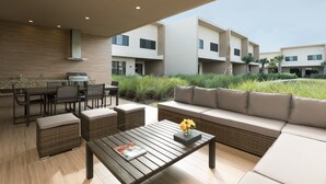 A modern outdoor patio with a dining area, a sofa, and a coffee table. - Near Disney/3BDR/Entire Home/Free Use of property Amenities/Wi-Fi/Parking (Kissimmee)
