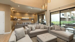 A spacious living area with multiple sofas and a coffee table, large windows with curtains, and a modern ceiling light fixture. - Near Disney/3BDR/Entire Home/Free Use of property Amenities/Wi-Fi/Parking (Kissimmee)