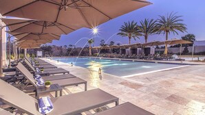A poolside area with lounge chairs and umbrellas, a swimming pool, and palm trees. - Near Disney/3BDR/Entire Home/Free Use of property Amenities/Wi-Fi/Parking (Kissimmee)