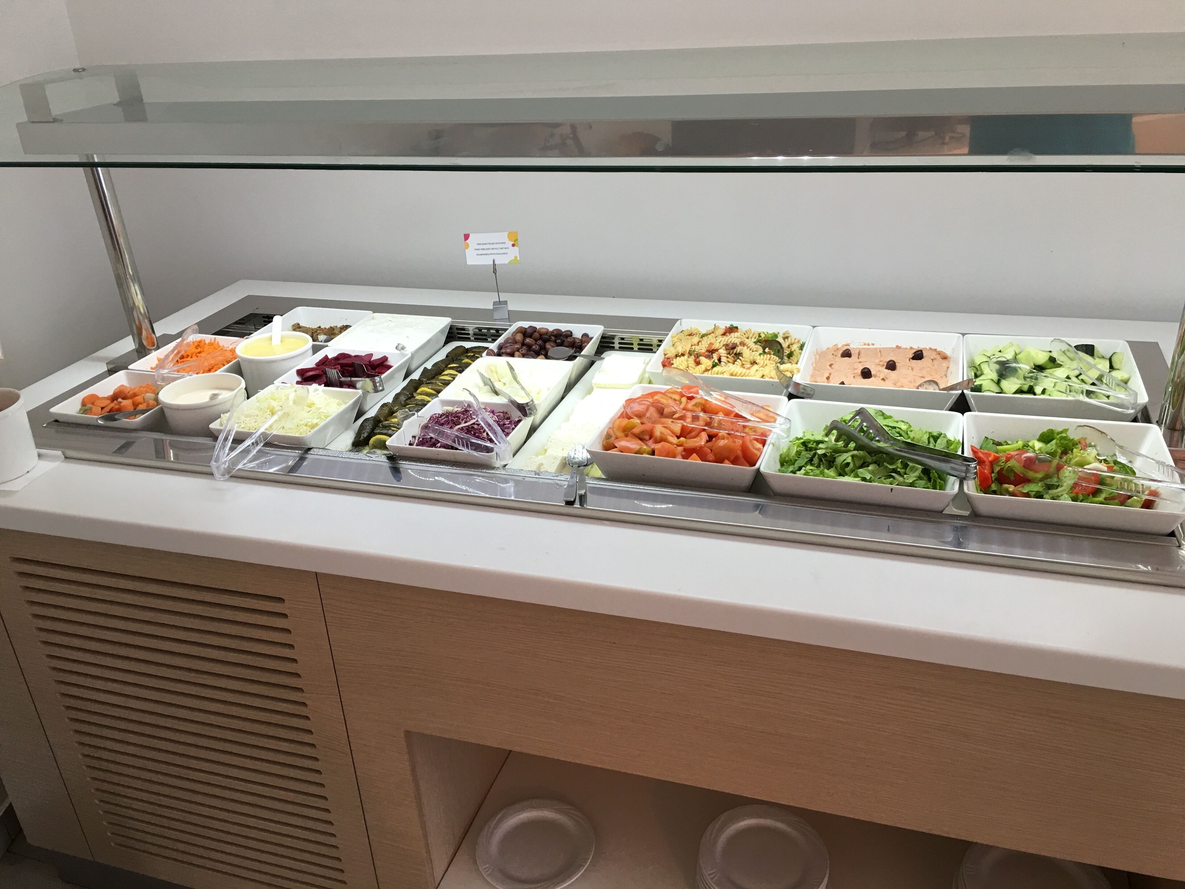 A buffet with various food items including salads, pasta, and vegetables.
